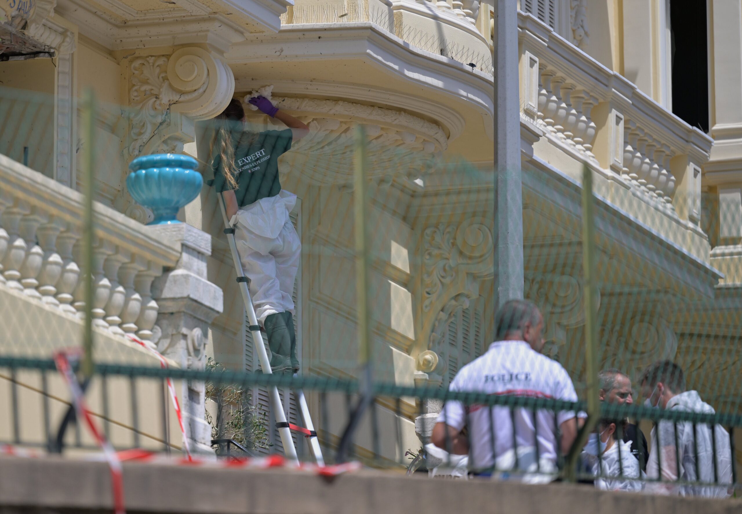 An investigator examines the scene at the residential building where an explosive device seriously injured three people a day earlier in Monaco, on June 30, 2026.