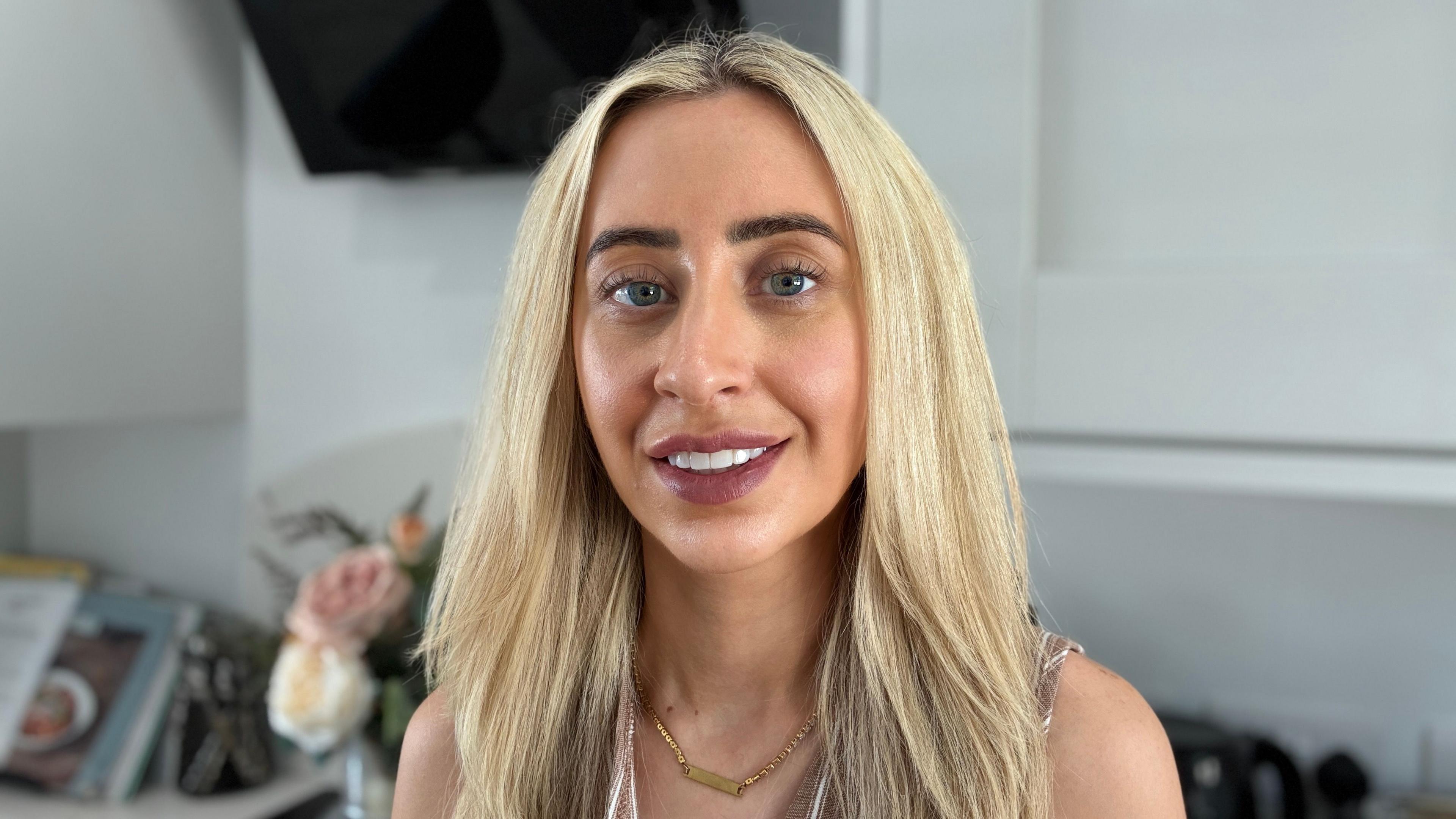 A woman with blonde hair smiling at the camera