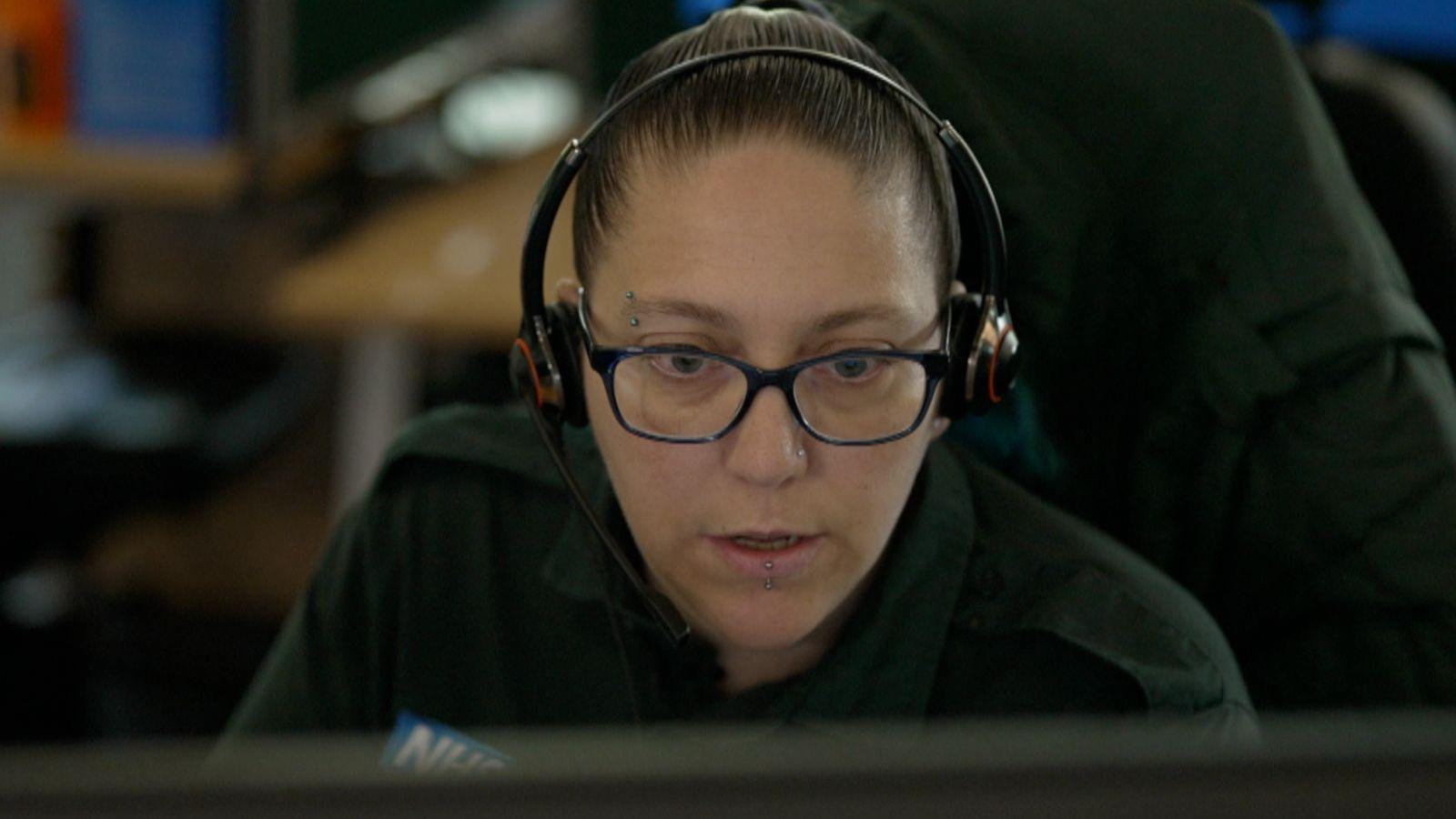 A female ambulance call handler with a headset staring at a computer screen