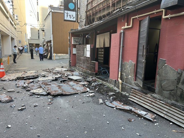 The exterior wall of a shop is seen collapsed in an earthquake, in Kumamoto City on July 28, 2026.