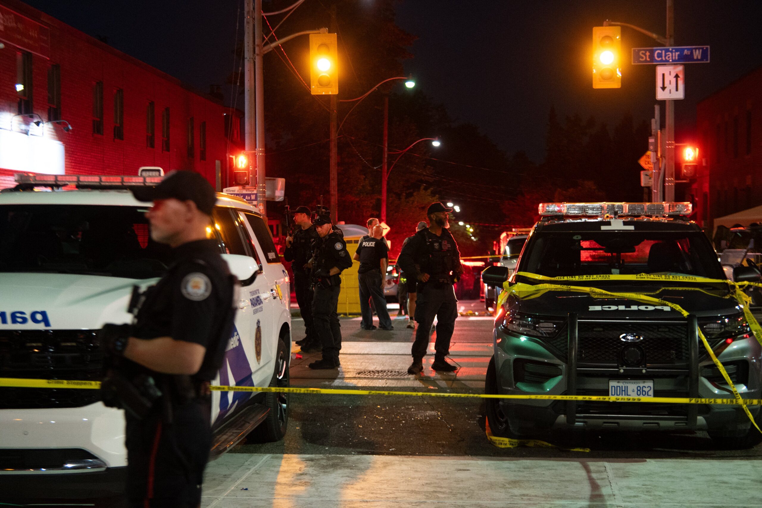 Police officers and other law enforcement personnel are seen at the intersection of St. Clair West and Arlington Avenue, near the site of a shooting that occurred at the Salsa on St. Clair Festival in Toronto on the evening of July 11, 2026. (Photo by Laura Proctor / AFP via Getty Images)