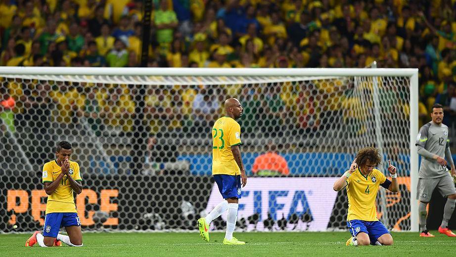 Brazil's players fall to their knees after a heavy defeat to Germany