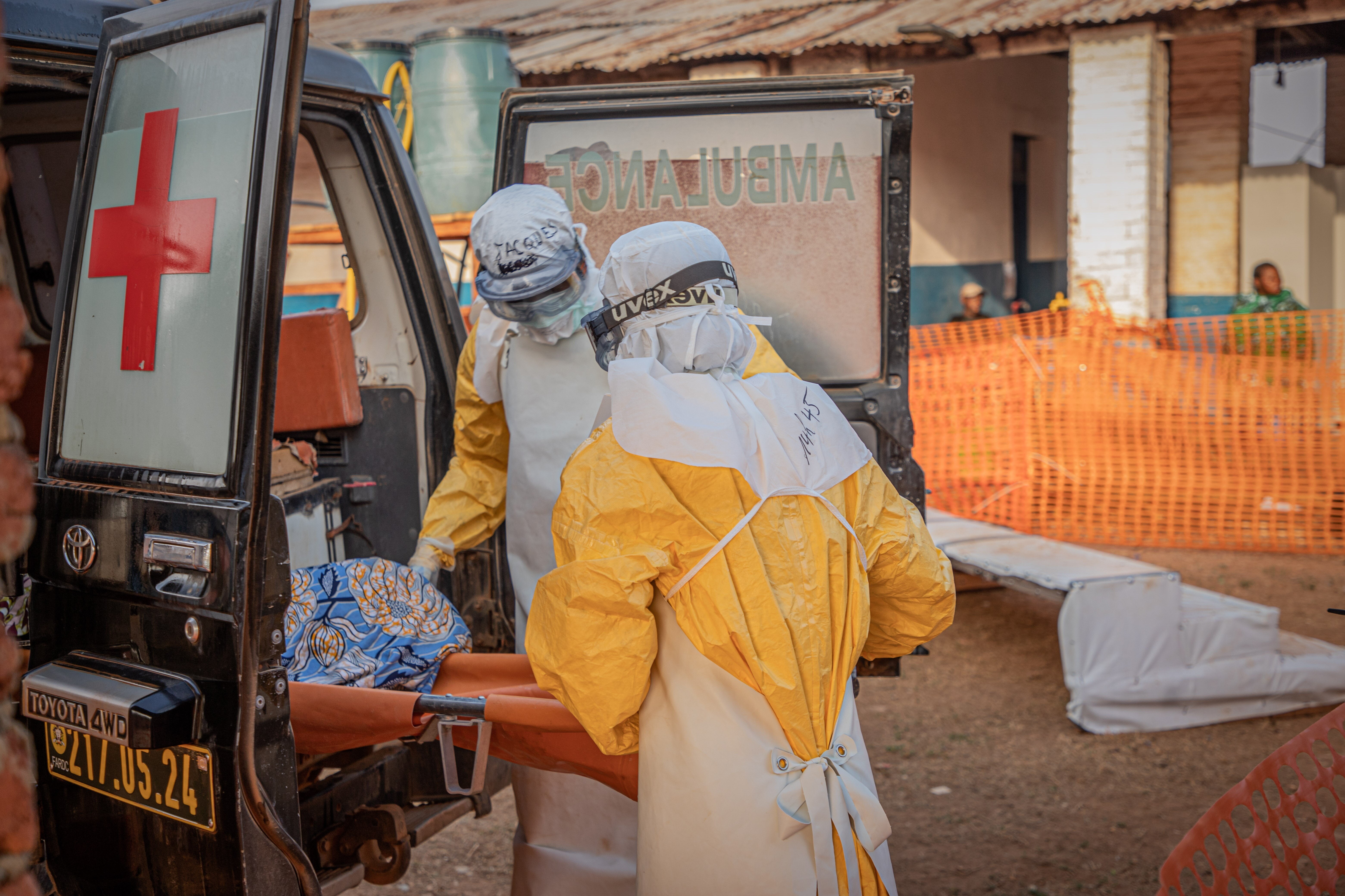 Medical workers escort an Ebola patient to an Ebola treatment center in Mongbwalu, Ituri Province, on June 20.