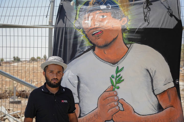 Awdah Hathaleen's nephew stands next to a banner depicting his uncle in Umm al-Khair, Masafer Yatta in the West Bank on Aug. 16, 2025. Hathaleen was assassinated by the Israeli settler Yinon Levi, prompting solidarity activities and commemorations in the village.