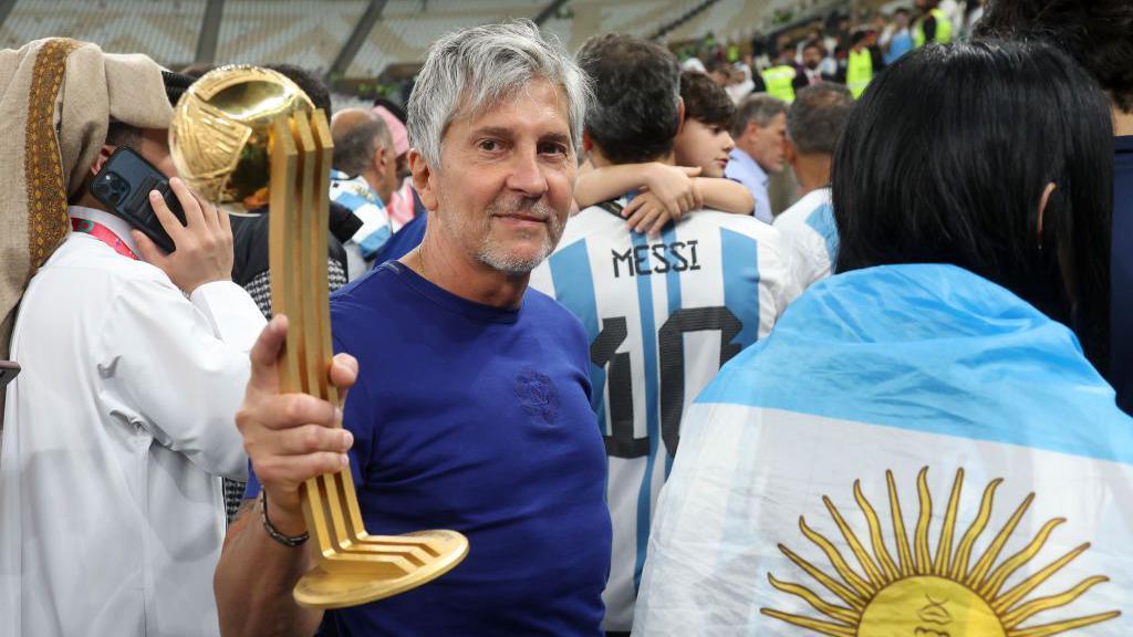 Jorge Messi holds up the best player award won by his son Lionel Messi at the World Cup