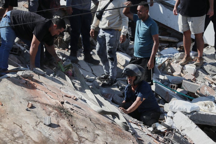 Residents and rescue workers search through the rubble of a collapsed building after an earthquake struck Cali, Colombia, on Aug. 10, 2026.
