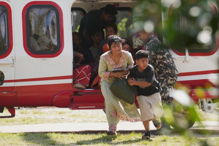 Army soldiers help a family disembark from a helicopter after they are rescued from an area affected by flash flooding in Nepal's Nuwakot district, Friday, Aug. 28, 2026. (AP Photo/Rajesh Kumar Singh)