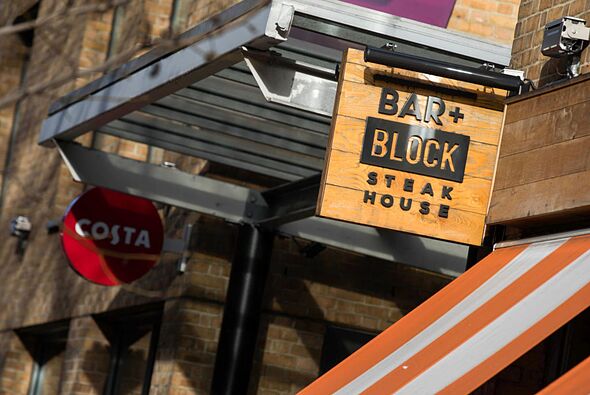 A sign hangs outside the entrance to a Bar and Block restaurant, operated by Whitbread Plc, in Londo