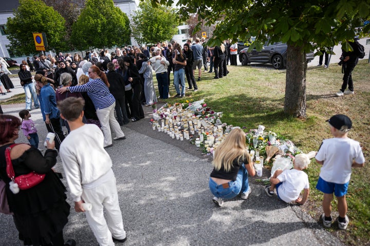 Fagersta residents leave flowers and candles at a makeshift memorial outside a school in Fagersta, central Sweden, on August 22, 2026, a day after a 17-year-old girl was killed and three other people were injured in a sword attack at the school. (Photo by Magnus LEJHALL / TT NEWS AGENCY / AFP via Getty Images)
