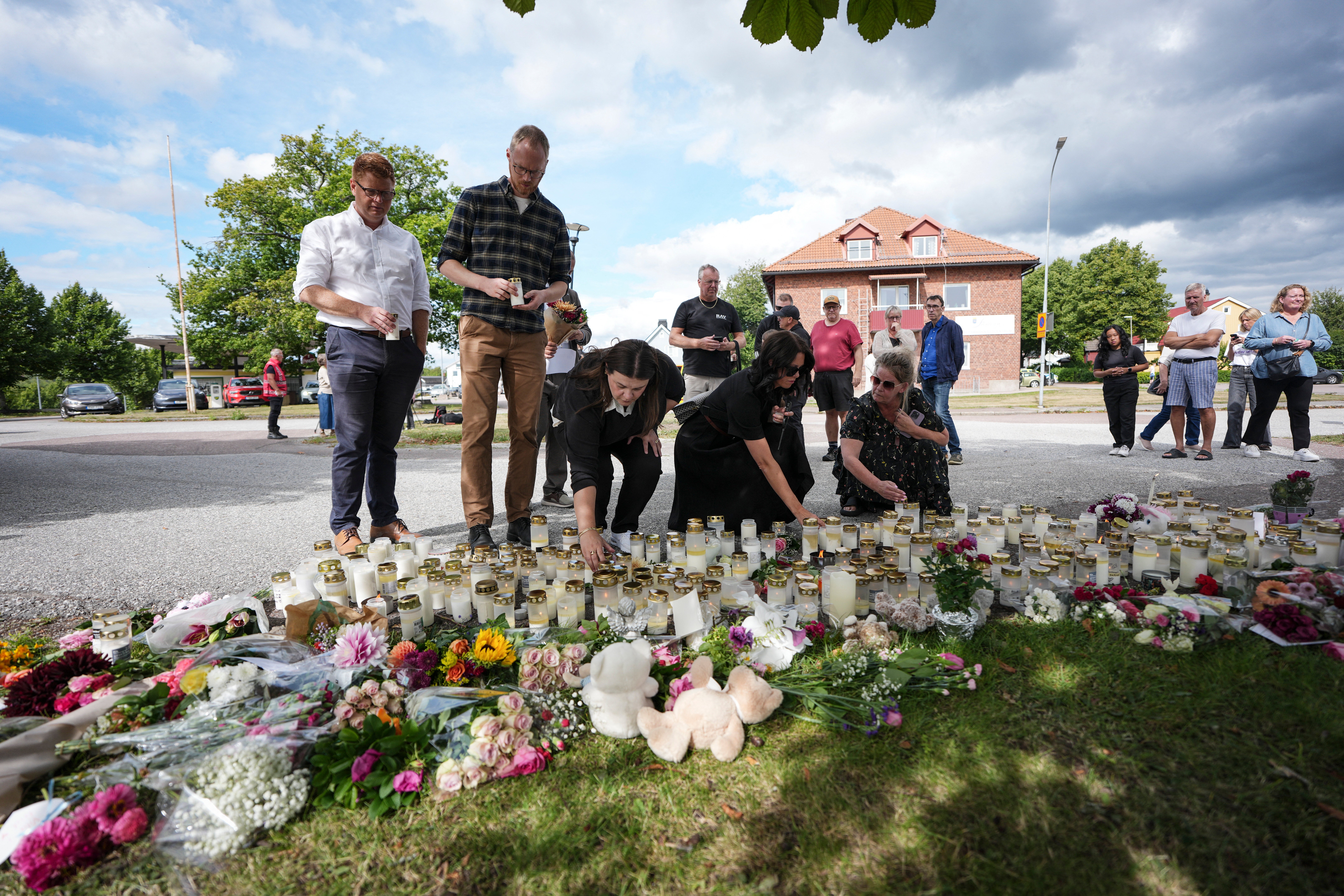 Fagersta residents leave flowers and candles at a makeshift memorial outside a school in Fagersta, central Sweden, on August 22, 2026, a day after a 17-year-old girl was killed and three other people were injured in a sword attack at the school. (Photo by Magnus LEJHALL / TT NEWS AGENCY / AFP via Getty Images)