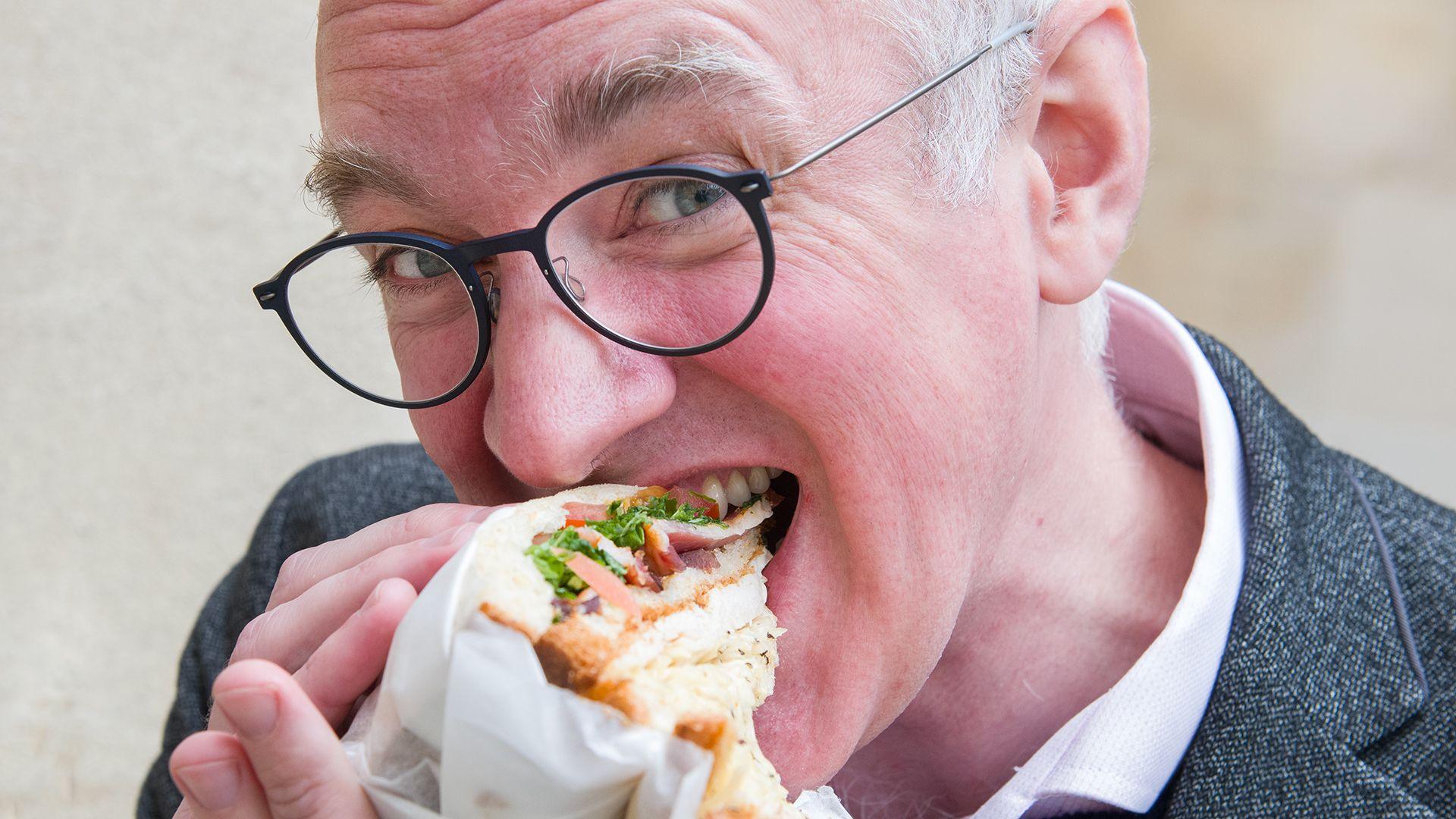 James Gallagher biting into a Gail's bacon and chicken club sandwich