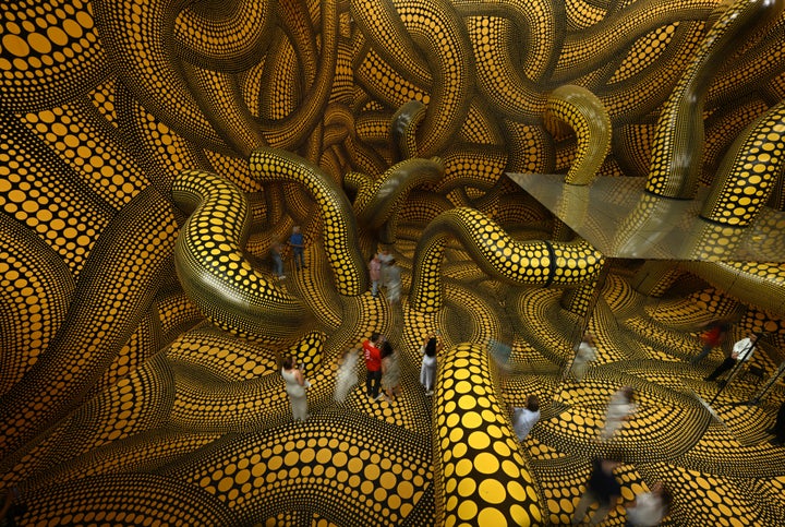 Visitors walk through the installation "Infinity Mirrored Room The Hope of the Polka Dots Buried in Infinity Will Eternally Cover the Universe" during the last day of the exhibition "Yayoi Kusama" by Japanese artist Yayoi Kusama at the Museum Ludwig in Cologne, western Germany, on August 2, 2026. (Photo by Ina FASSBENDER / AFP via Getty Images)