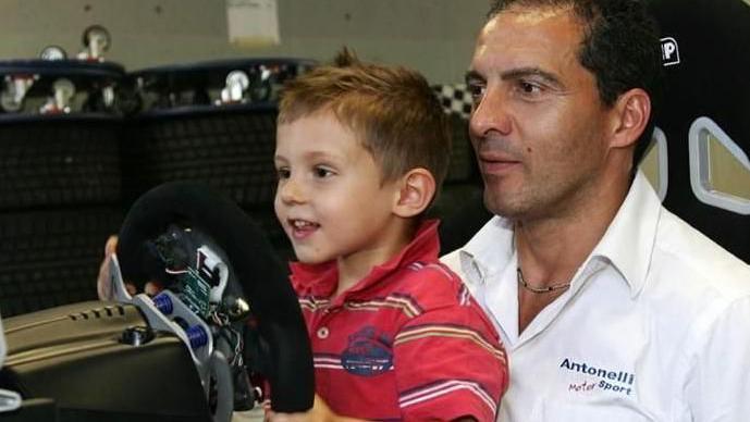 A young Kimi Antonelli sitting on his dad's lap while steering a car