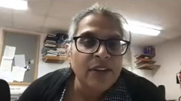 A video shot of Kuldeep Stohr giving a lecture to Orthopaedic Academy. She wears brown glasses and has hair tied back in a ponytail, wearing a black cardigan.