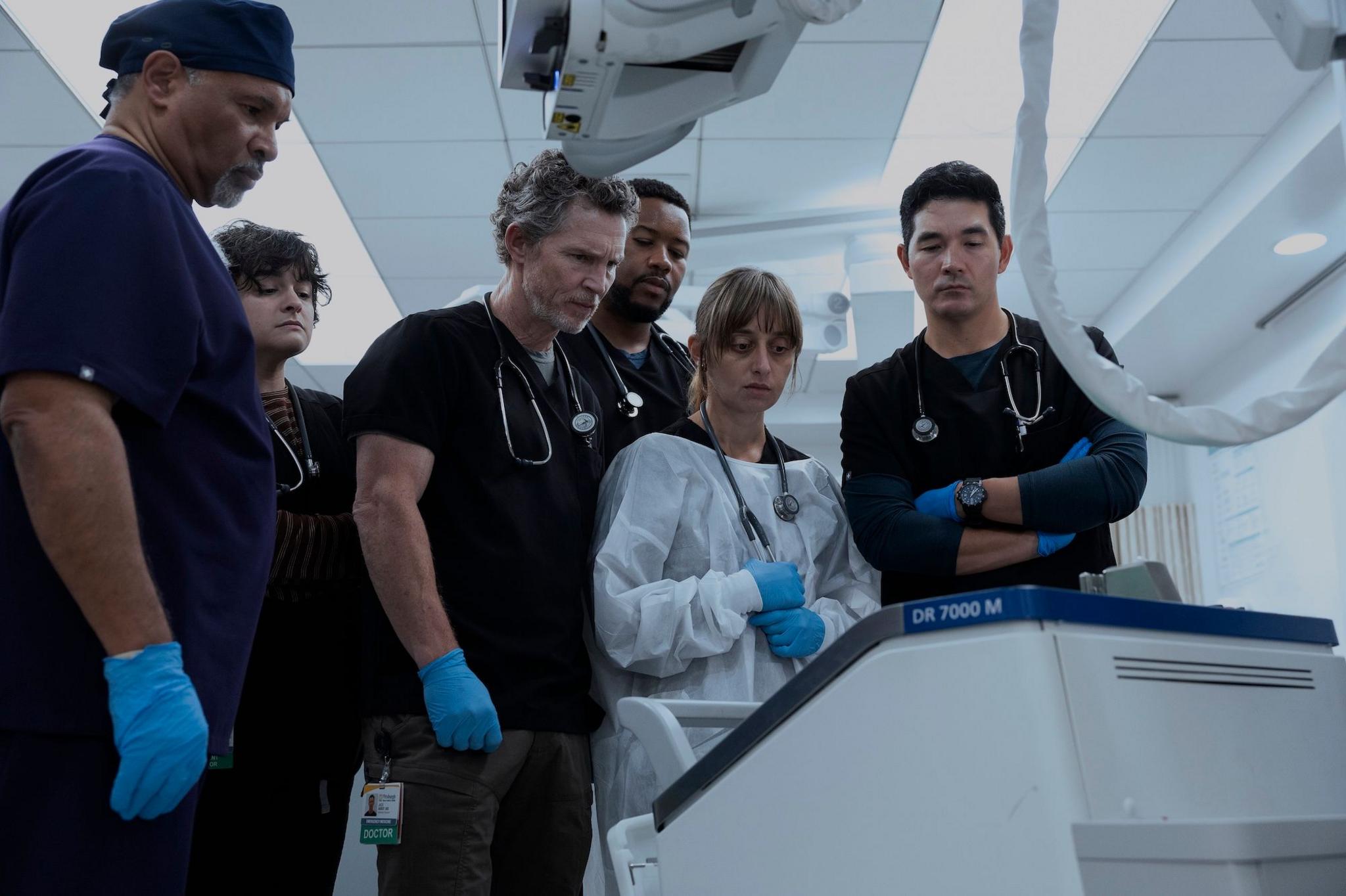 A group of medical staff gather round a hospital machine