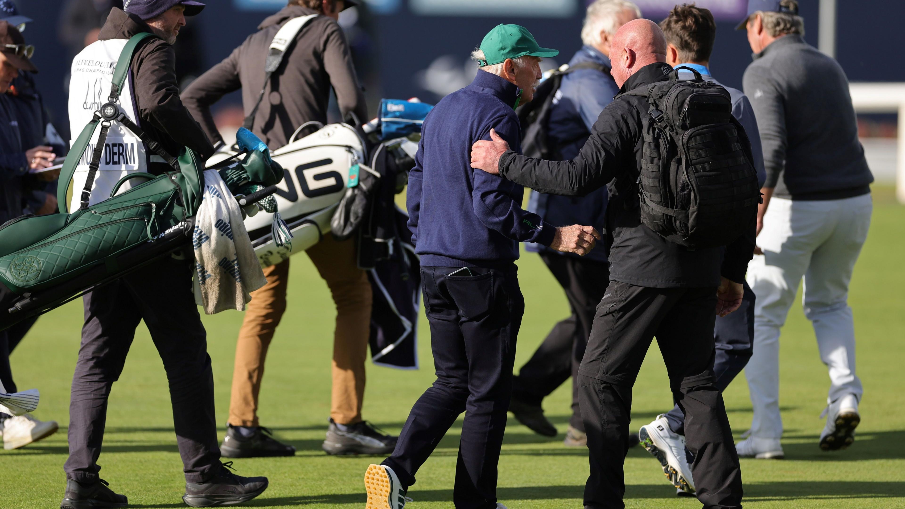 Dermot Desmond being escorted off the golf course by security