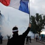French police use tear gas and water cannons after some protests turn violent as shopkeepers board up storefronts across Paris