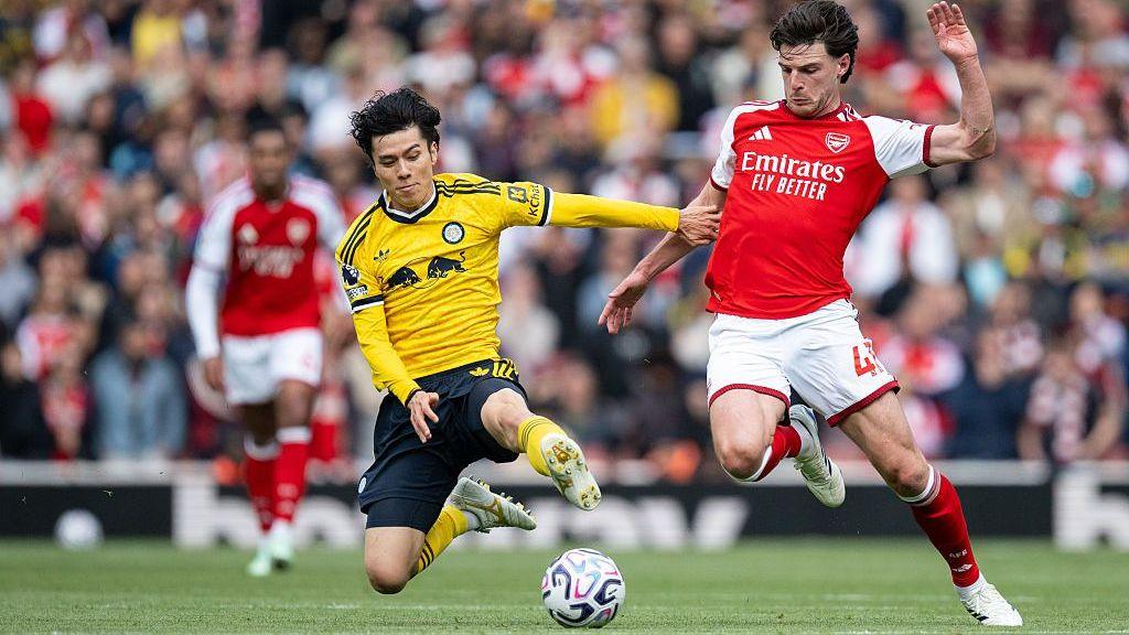 Tanaka and Rice battle for the ball.