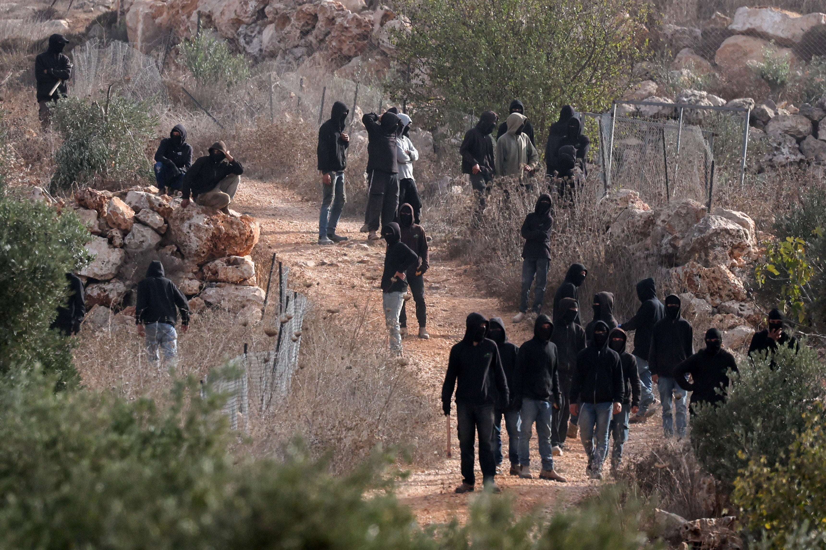 Israeli settlers dressed in black assemble in Abu Falah on Oct. 16, 2026. Israeli Prime Minister Benjamin Netanyahu claims they didn’t attack anyone, but video footage shows otherwise.