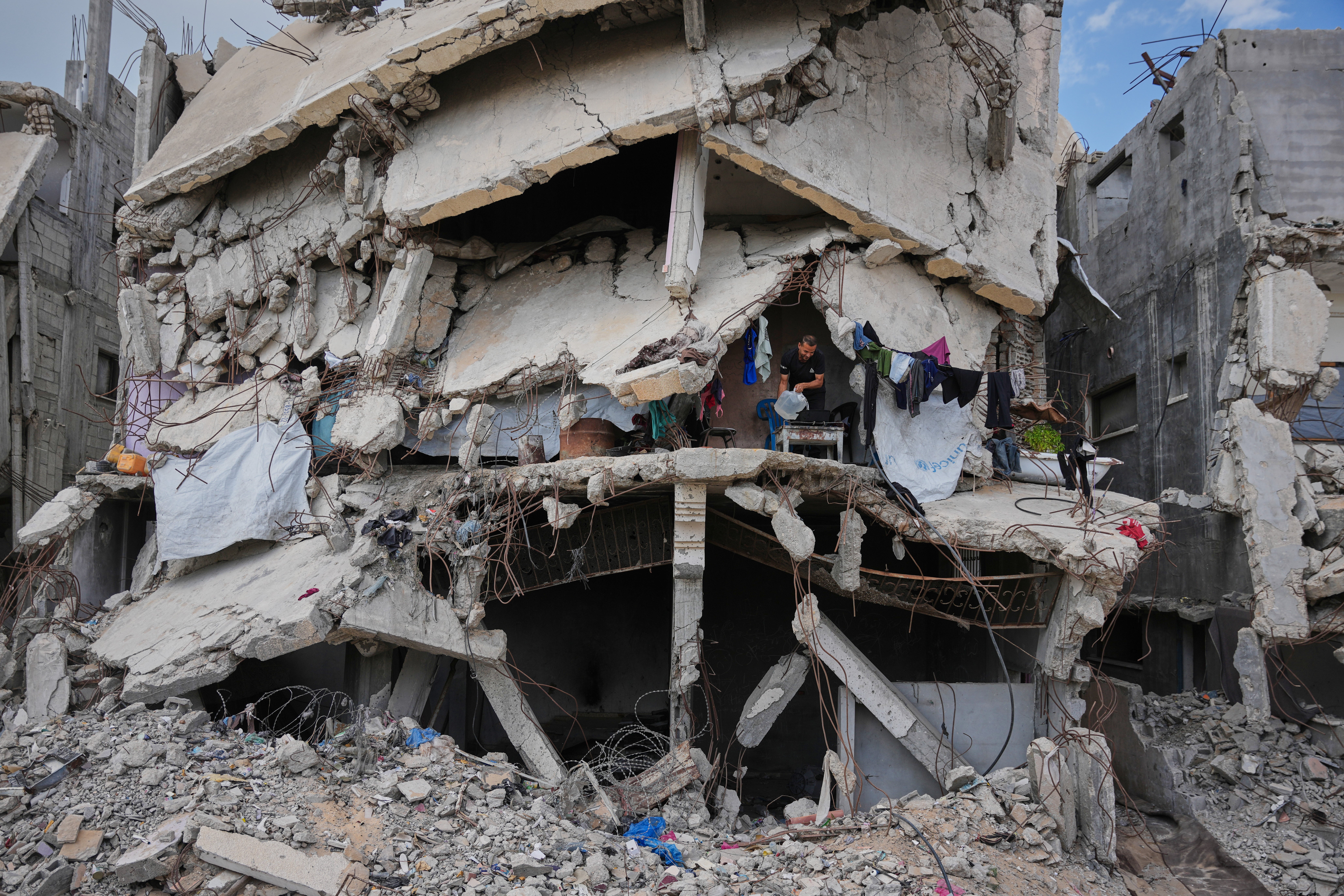 Murid Akhziq, 43, lights a fire for cooking inside his home, which was destroyed during the Israel-Hamas war, in Gaza City, Tuesday, Oct. 6, 2026. (AP Photo/Abdel Kareem Hana)