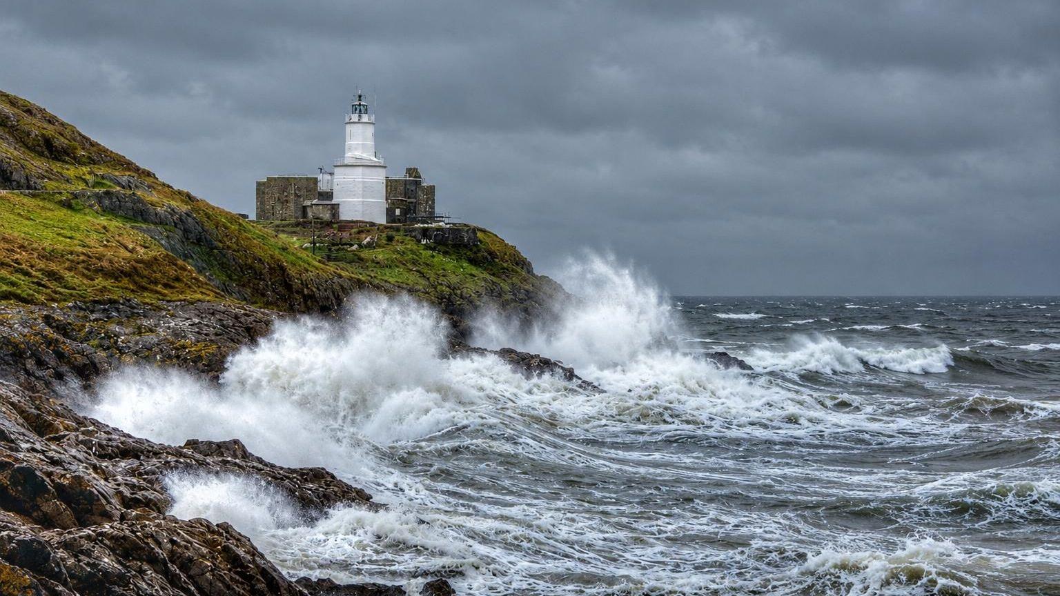 Waves are seen crashing against a cliffe