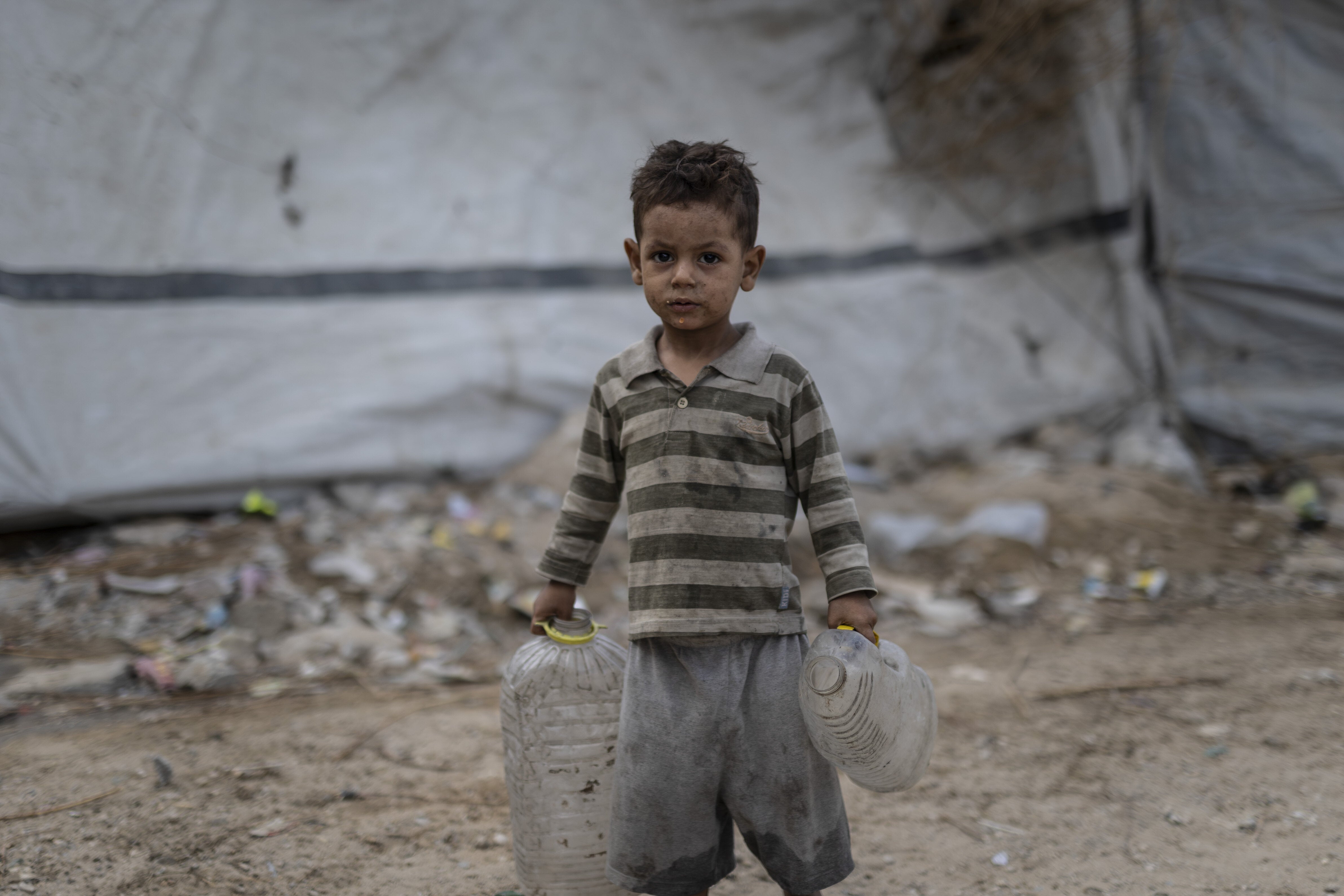 A boy carries empty bottles as Palestinian families displaced by Israel's relentless bombardment of the Gaza Strip struggle to survive in makeshift tents in Gaza City, Gaza, on Sept. 29, 2026. Civilians are unable to access basic humanitarian necessities such as food, clean water, medical supplies and shelter due to Israel's tight blockade.
