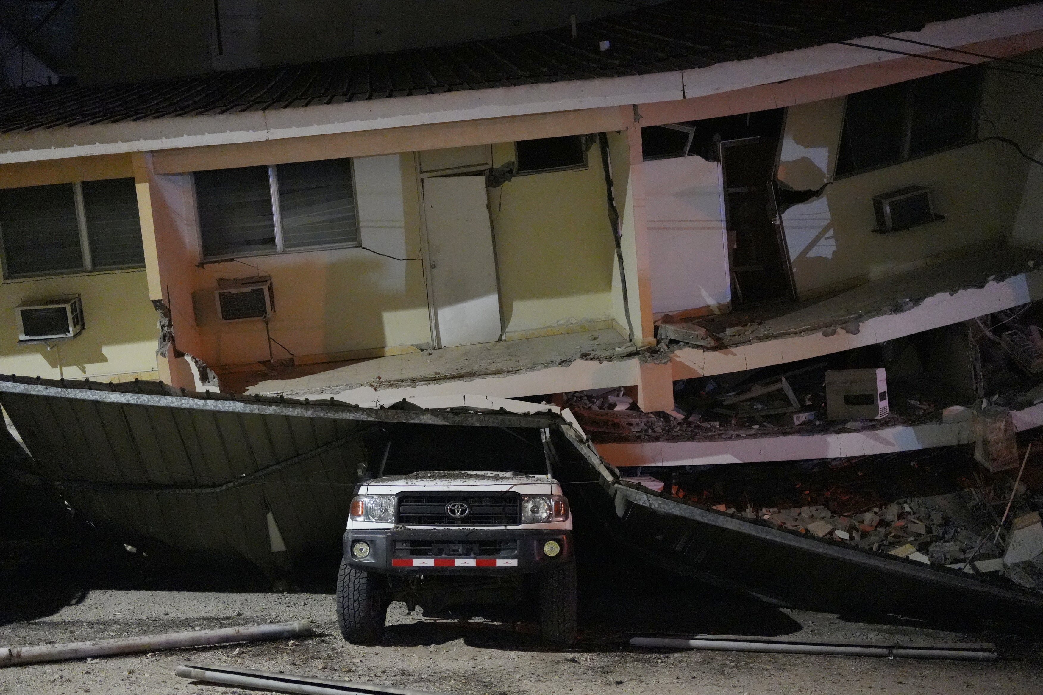 A vehicle lies crushed beneath a collapsed building after an earthquake struck Penonome, Panama, Friday, Oct. 9, 2026. (AP Photo/Aris Mariota)