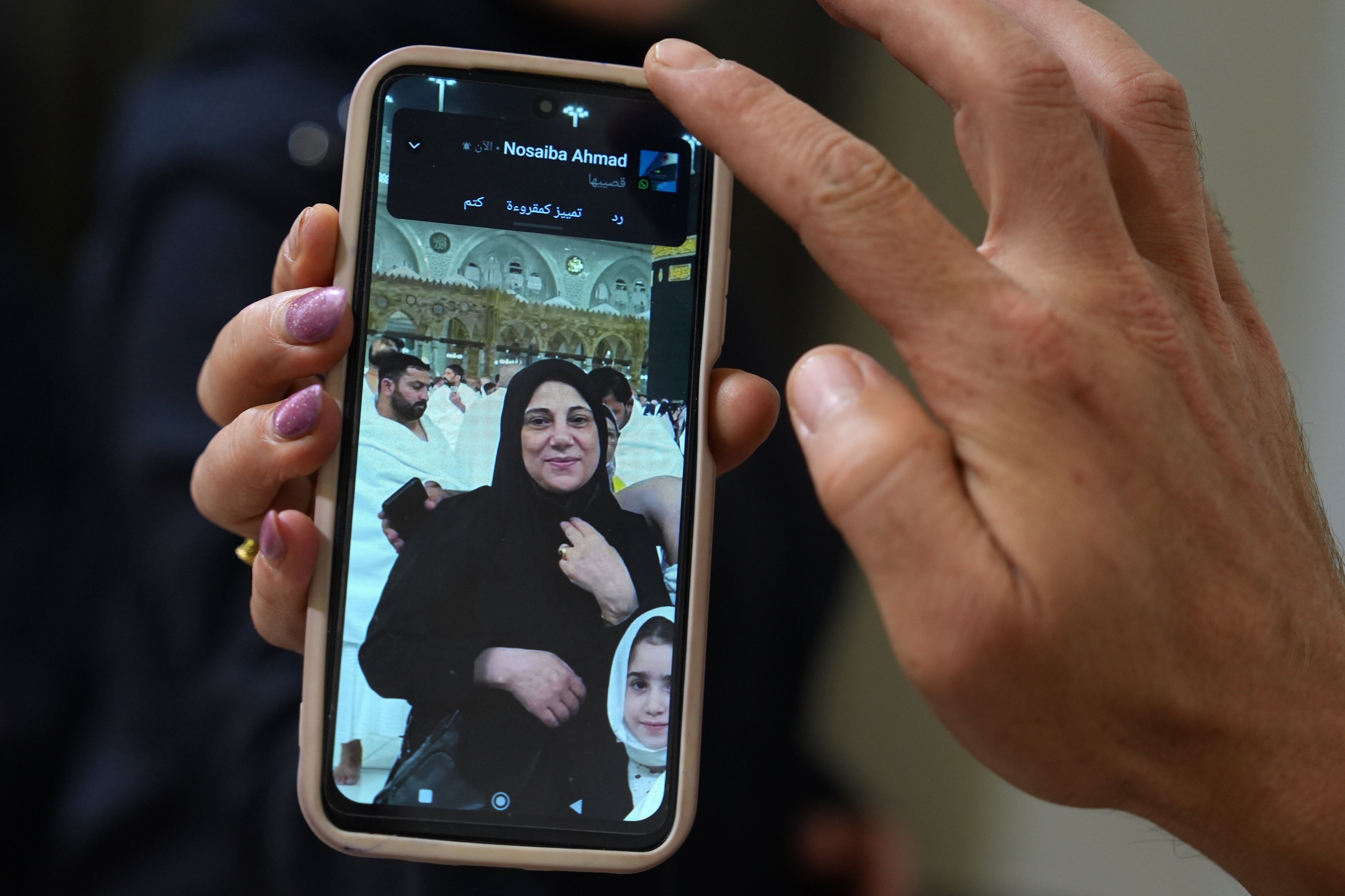 A portrait of Buthaina Ahmad Oweida, the Syrian woman who died in yesterday's attack on the Riyadh airport, is displayed on the mobile phone of her nephew at her family house, in her hometown of Hafasraja, Idlib province, Syria, Oct. 11, 2026. (AP Photo/Omar Albam)