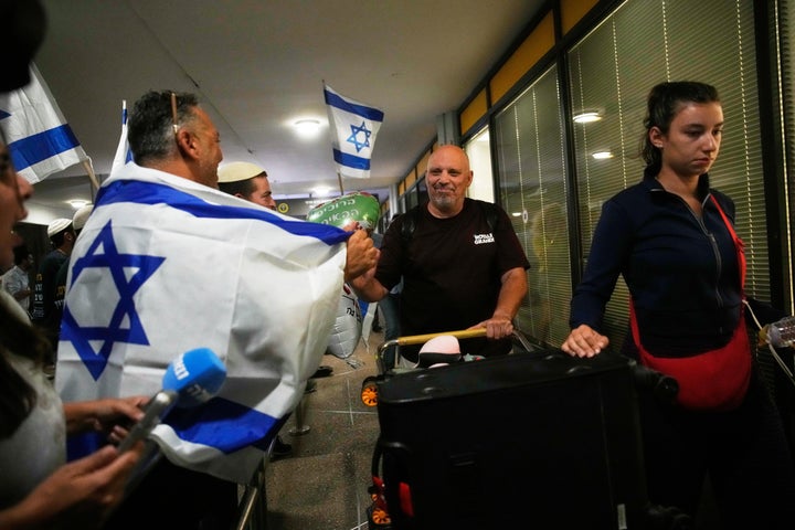 People carrying Israeli flags gather at the arrivals gate to greet Israeli passengers who had been aboard a FlyDubai aircraft that made an emergency landing in Saudi Arabia, at Ben Gurion International Airport near Tel Aviv, Israel, on Sept. 30, 2026.