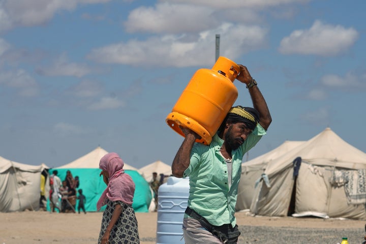 Displaced Yemenis receive humanitarian aid supplies at the Al-Firdaws camp in Ras Imran, west of Aden, Yemen, on Monday, Oct. 5, 2026.
