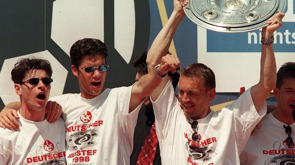 Michael Ballack celebrates with Kaiserslautern T-shirts as they wear white T-shirts with red lettering signalling the team's 1998 Bundesliga title win