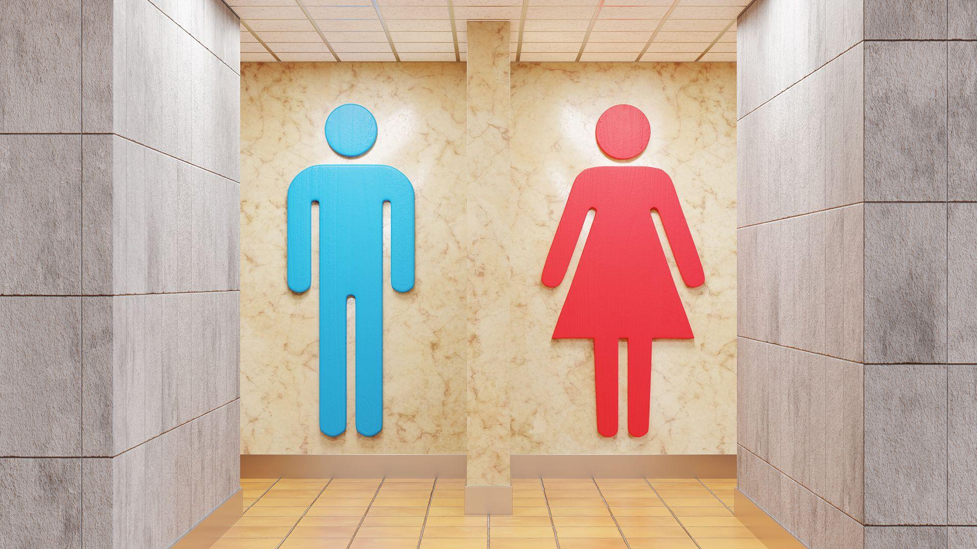 Stock photo shows two entrances to single space public toilets - designated by large signs of a man in blue and a woman in red.